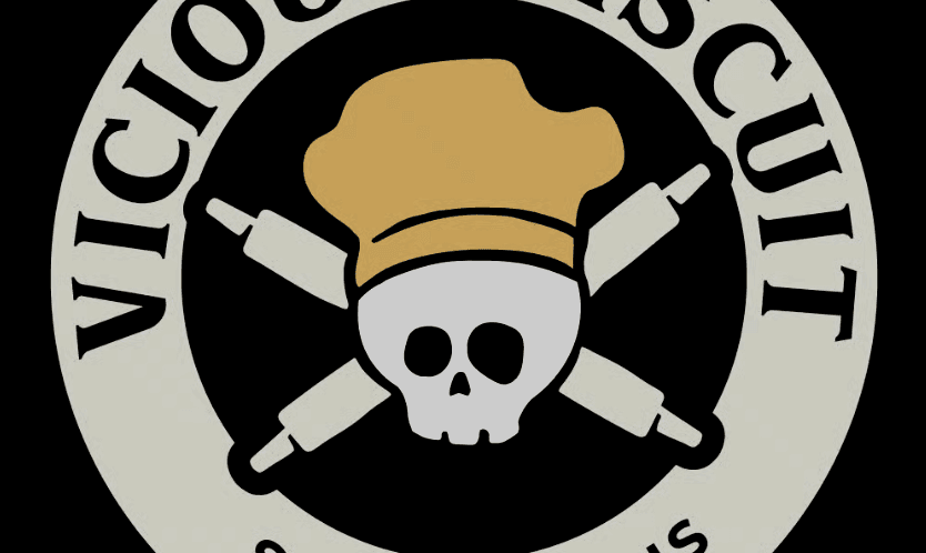 A logo featuring a skull in a chef’s hat with crossed rolling pins behind it, surrounded by the words “Vicious Biscuit”—a bold tribute to delicious Southern cooking and unforgettable brunch moments.